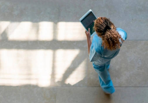 A medical professional walking with an electronic tablet