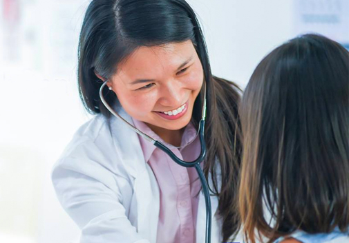 A friendly clinician examining a young patient.