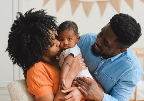 A family hugging and kissing their infant child