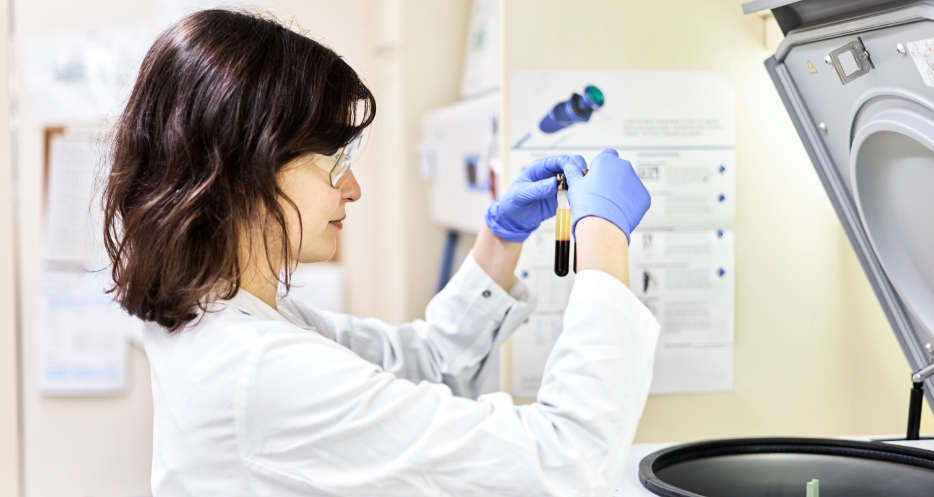 A lab employee analyzing two vials of samples.