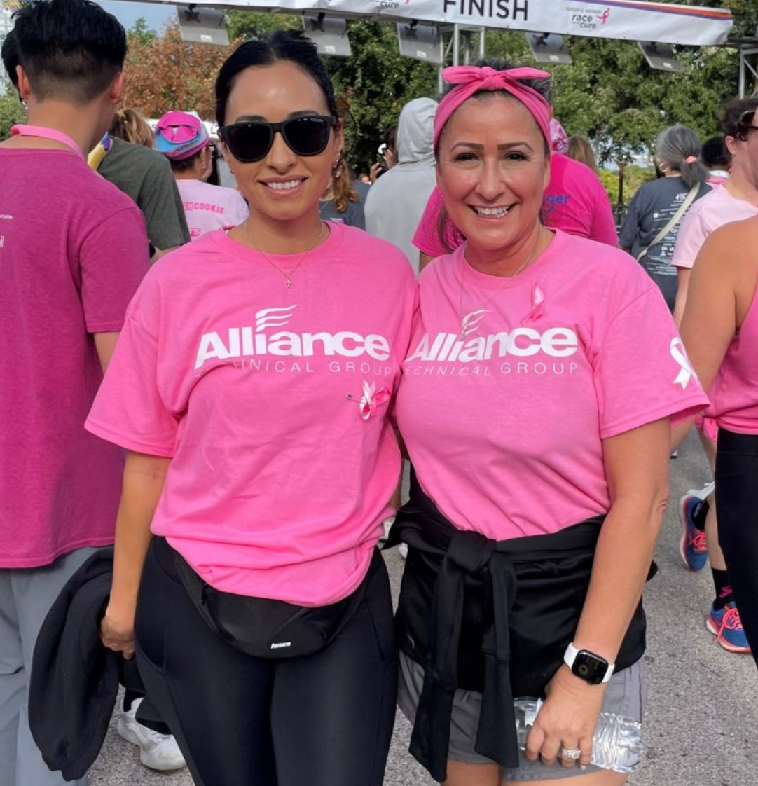 Two Alliance employees smiling together at a charity event