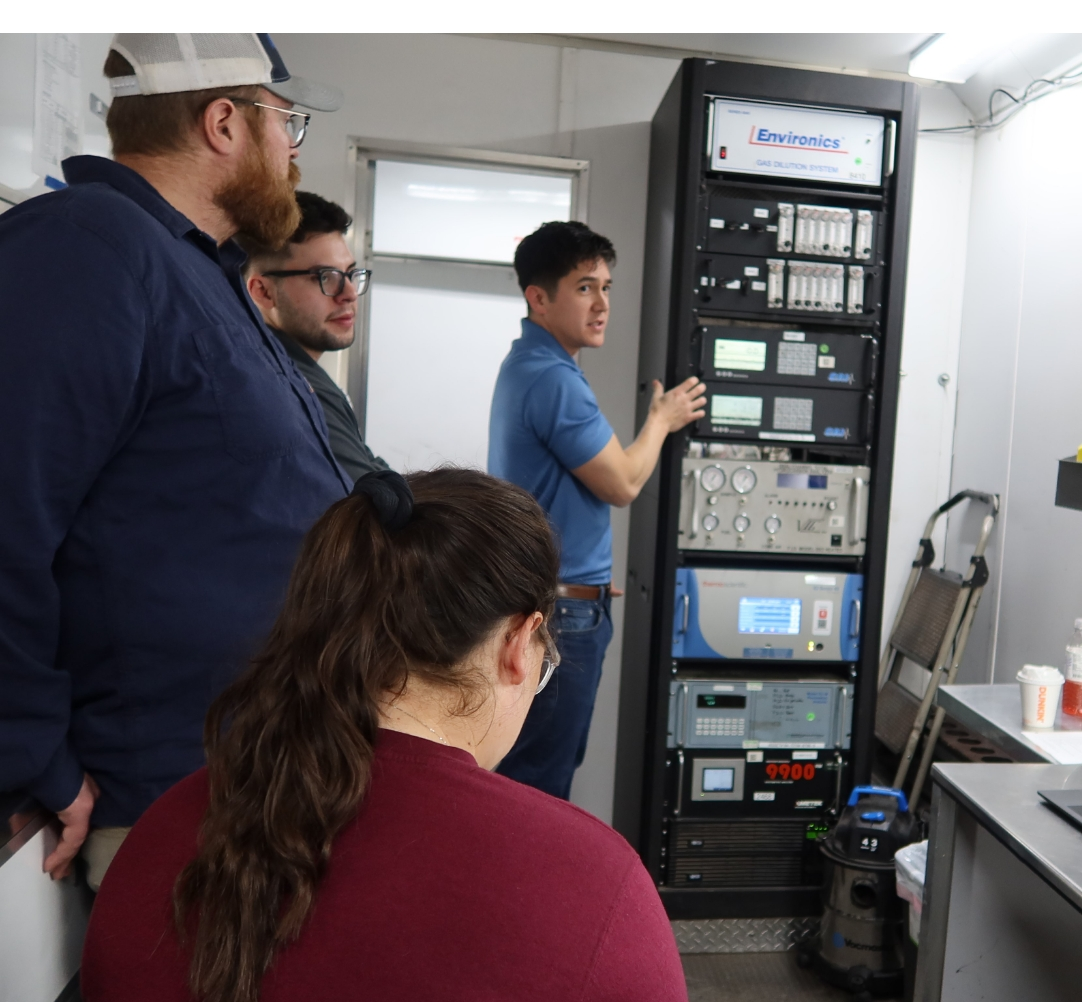 Four employees smiling and chat with one another.