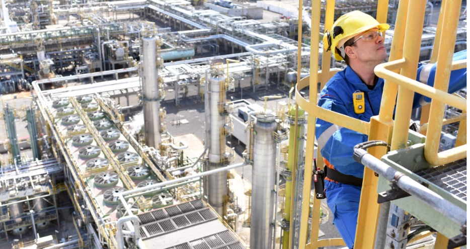 Close-up of a technician in PPE gear climbing a stack ladder.