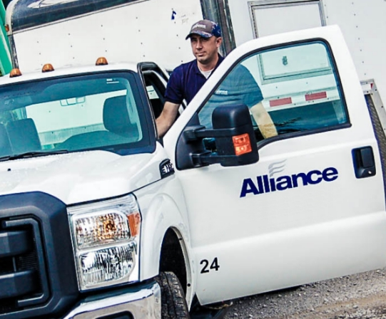 A technician exiting an Alliance company truck.