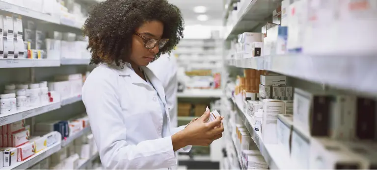 A pharmacy professional evaluating a medicine bottle.